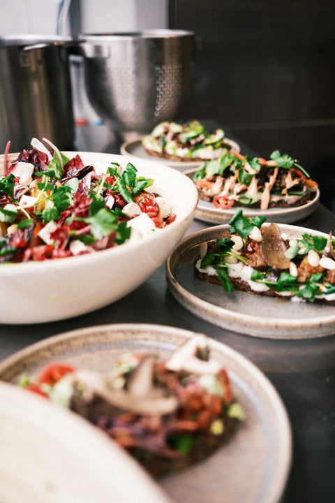 Op een aanrecht zie je salade en broodjes