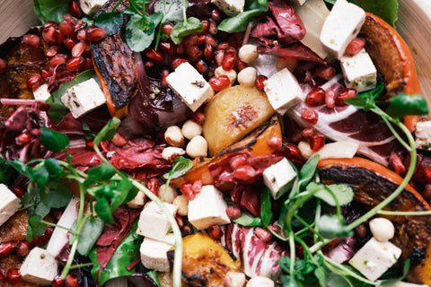Van boven een salade met pompoen, feta en granaatappel in de vorm van een close up