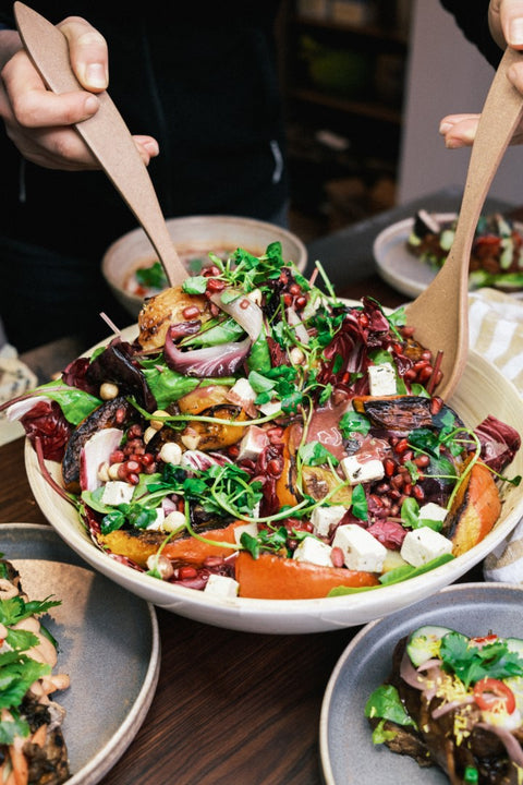 Met slabestek wordt een salade doorgeroerd